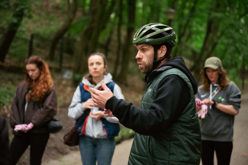 Male instructor explains how to plant ivy in the park